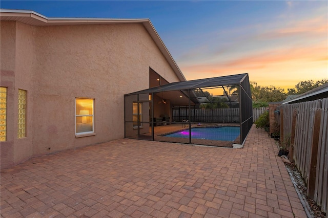 8701 Ballantrae Way, Tampa, FL 33647 - pool at dusk with a patio and glass enclosure
