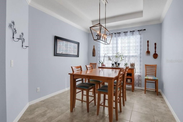 dining space with light tile patterned floors, baseboards, a raised ceiling, and crown molding