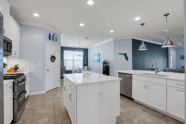 kitchen featuring appliances with stainless steel finishes, a kitchen island, crown molding, and a sink