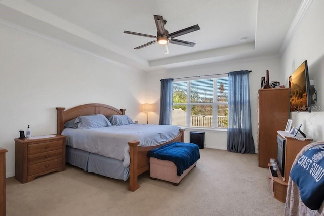 bedroom with a raised ceiling, carpet floors, ceiling fan, and crown molding