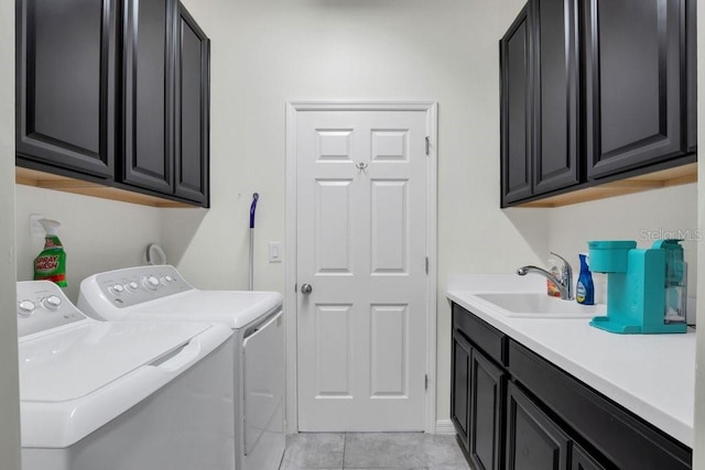 clothes washing area with washer and clothes dryer, light tile patterned floors, cabinet space, and a sink