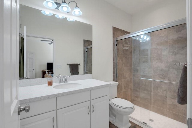 bathroom with a shower with door, vanity, and toilet