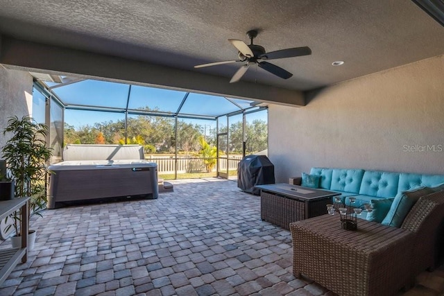 view of patio with an outdoor hangout area, ceiling fan, glass enclosure, grilling area, and a hot tub