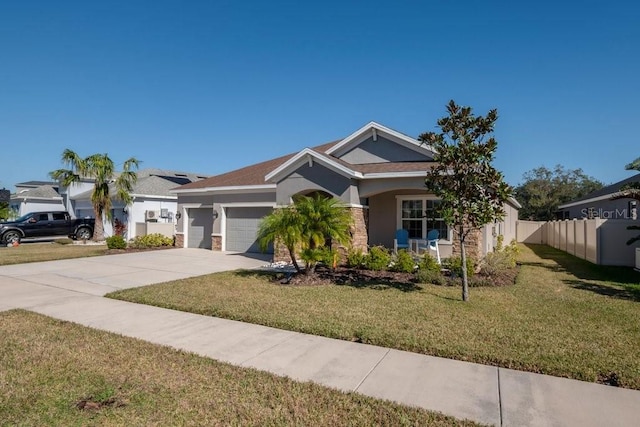 view of front of property with stucco siding, a front lawn, fence, concrete driveway, and an attached garage