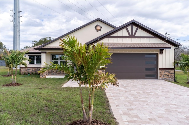 view of front of property with an attached garage, stone siding, decorative driveway, a front lawn, and board and batten siding