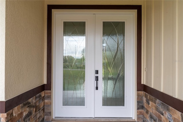 entrance to property with french doors and stucco siding