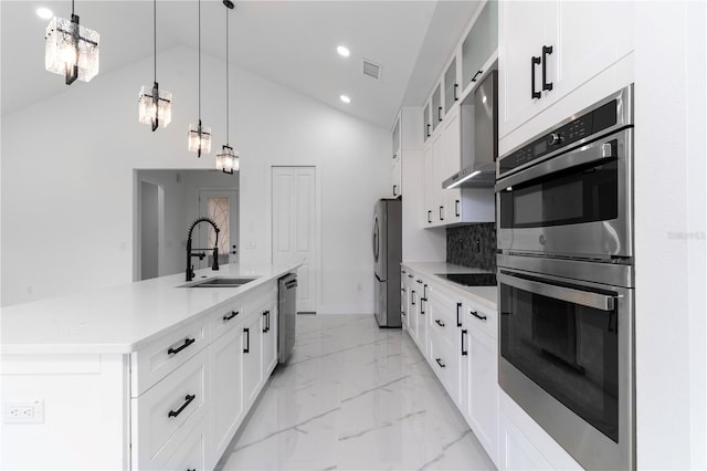 kitchen featuring marble finish floor, appliances with stainless steel finishes, a kitchen island with sink, a sink, and wall chimney exhaust hood