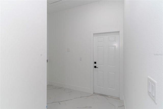 corridor with marble finish floor and baseboards