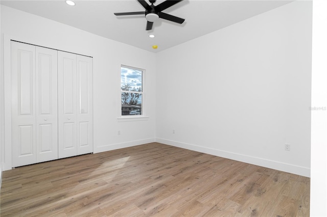 unfurnished bedroom featuring ceiling fan, light wood-type flooring, and a closet