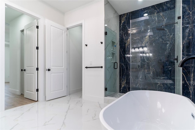 bathroom with marble finish floor, a marble finish shower, and a freestanding tub