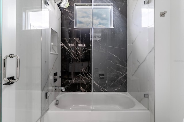 bathroom with bath / shower combo with glass door