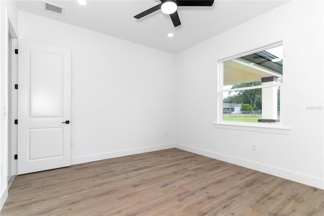 empty room with ceiling fan and light hardwood / wood-style flooring