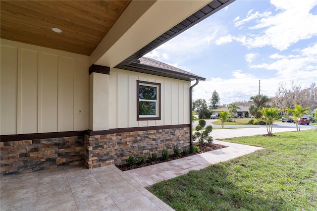 view of side of property featuring a yard and a patio