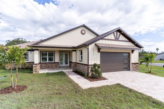 craftsman-style house featuring board and batten siding, french doors, decorative driveway, and stone siding