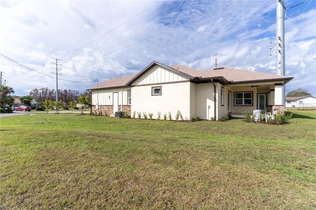 view of side of home featuring ceiling fan, a yard, and central air condition unit