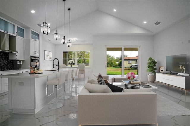 living room with visible vents, marble finish floor, high vaulted ceiling, a chandelier, and recessed lighting