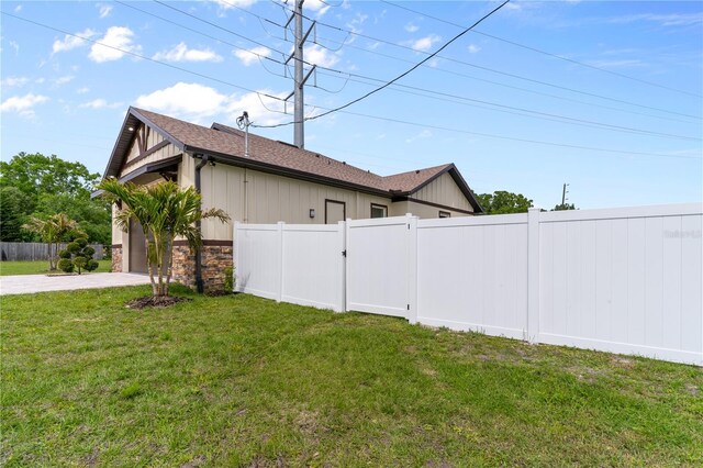 2972 Lake Saxon Dr, Land O Lakes, FL 34639 - view of home's exterior featuring board and batten siding, a shingled roof, stone siding, a garage, and concrete driveway