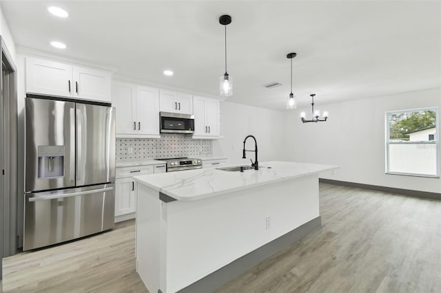 kitchen with an island with sink, white cabinets, and appliances with stainless steel finishes