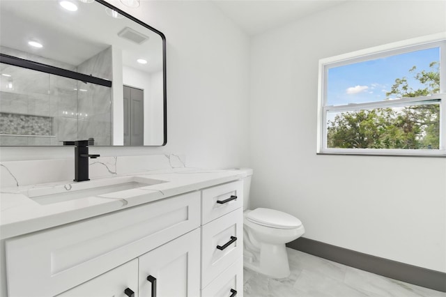 bathroom with vanity, a shower with door, and toilet