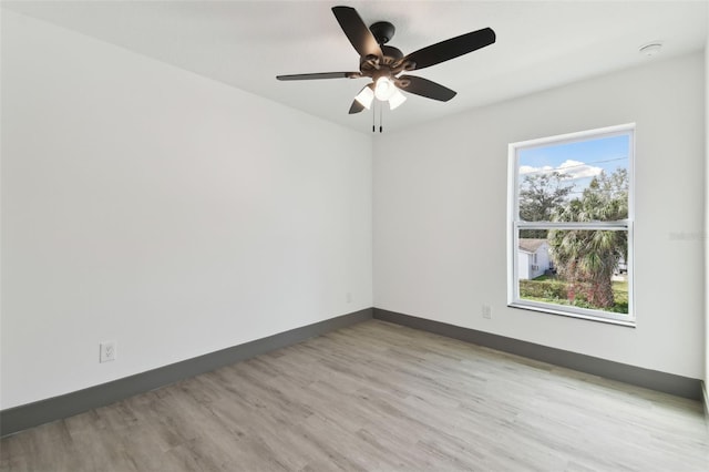 spare room with ceiling fan and light wood-type flooring