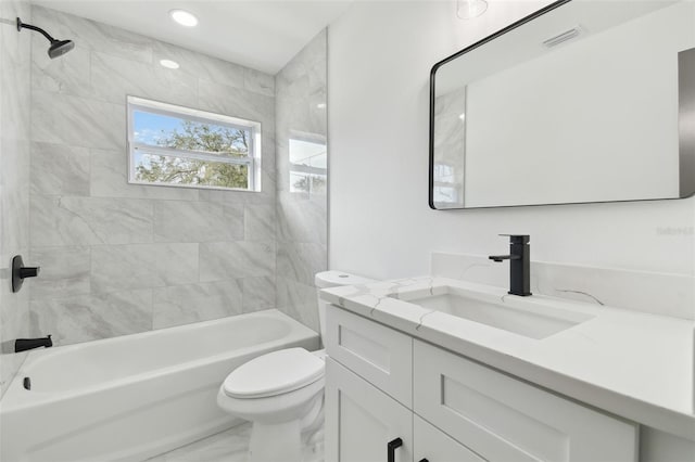 full bathroom featuring tiled shower / bath, vanity, and toilet