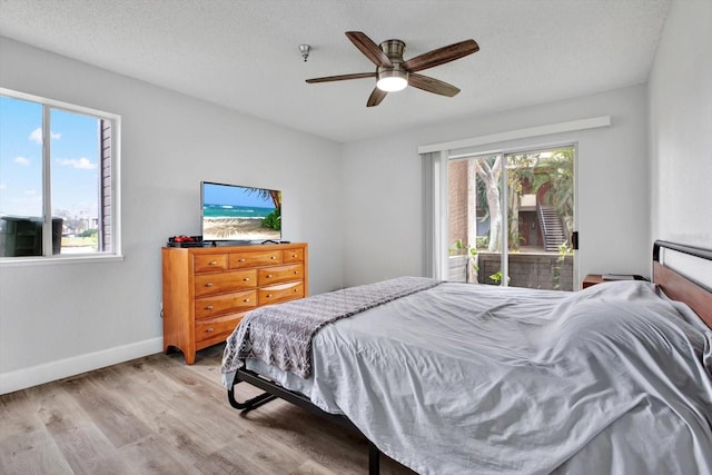 bedroom featuring ceiling fan, light hardwood / wood-style floors, and a textured ceiling