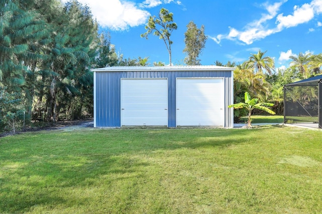 view of outdoor structure featuring a lawn and a garage