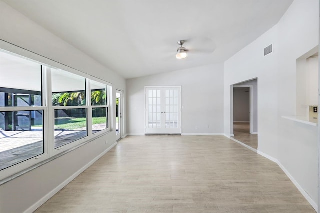 empty room with french doors, light hardwood / wood-style floors, ceiling fan, and lofted ceiling