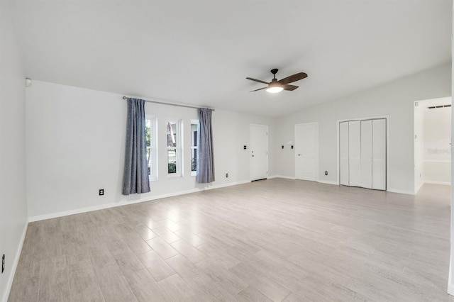 unfurnished room with ceiling fan, lofted ceiling, and light wood-type flooring