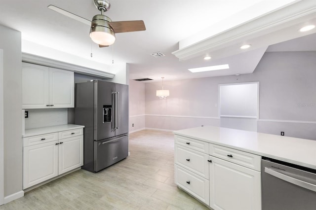 kitchen featuring white cabinets, hanging light fixtures, ceiling fan, light wood-type flooring, and appliances with stainless steel finishes