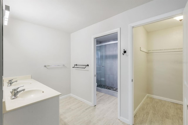 bathroom with vanity, wood-type flooring, and a shower with door