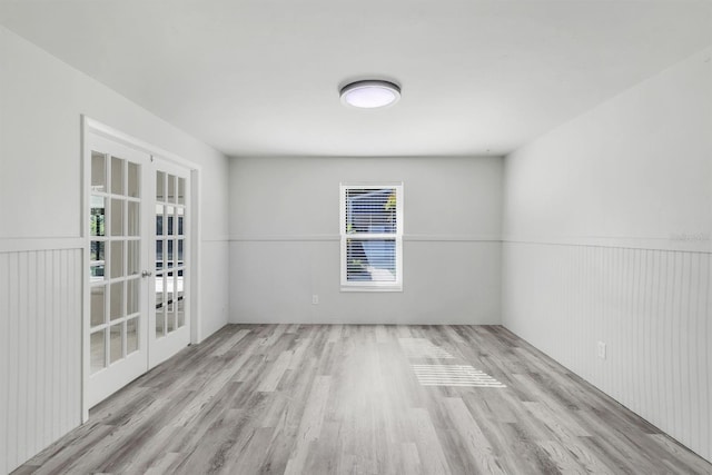 spare room with french doors and light wood-type flooring