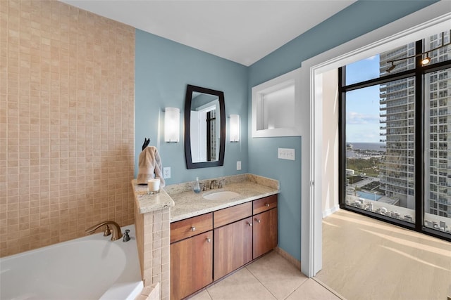 bathroom featuring vanity, a relaxing tiled tub, and tile patterned floors