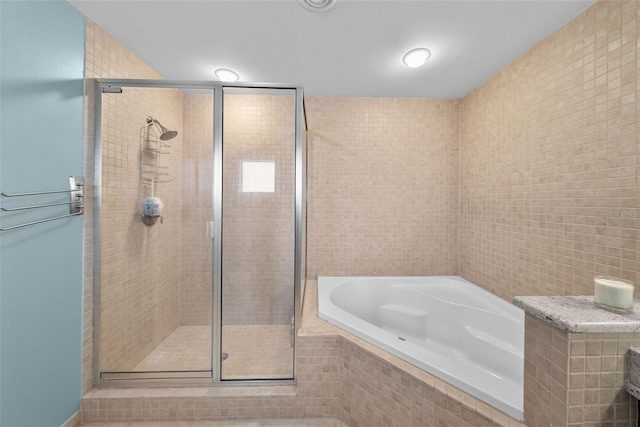 bathroom featuring shower with separate bathtub