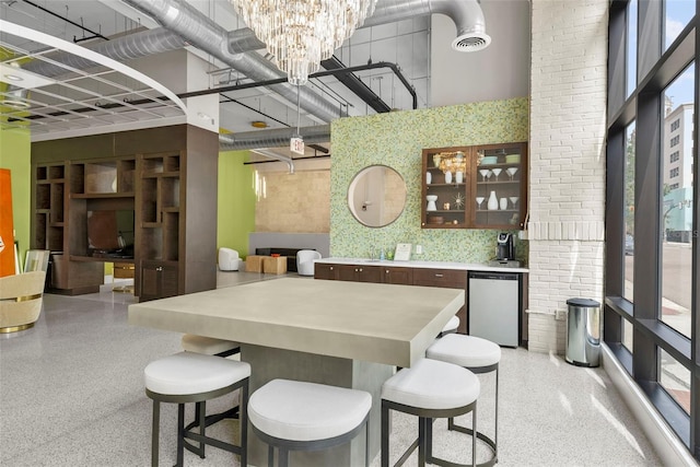 dining space featuring a towering ceiling and a notable chandelier