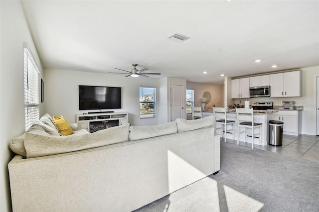 tiled living room with ceiling fan