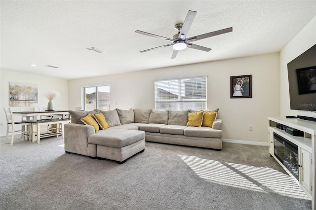 carpeted living room with ceiling fan and a textured ceiling