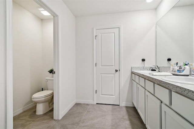 bathroom with tile patterned flooring, vanity, and toilet