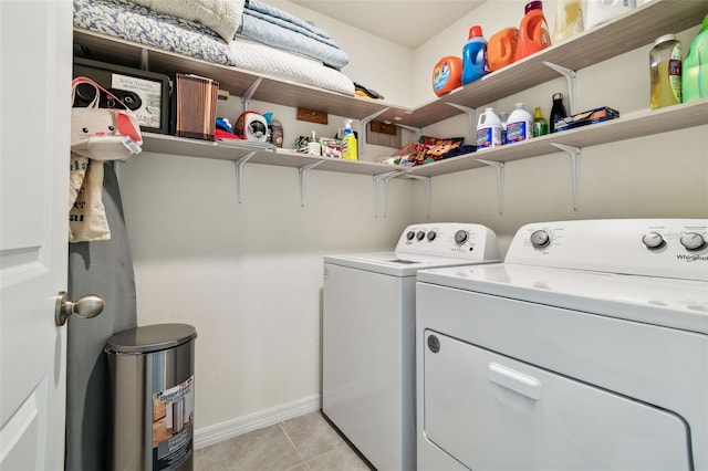 laundry area with light tile patterned floors and washer and clothes dryer