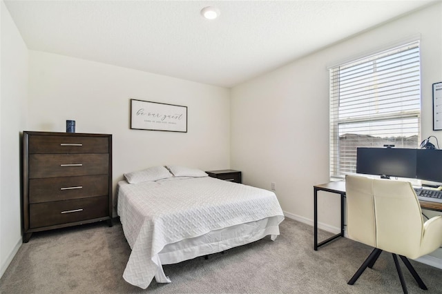 bedroom featuring light carpet and a textured ceiling