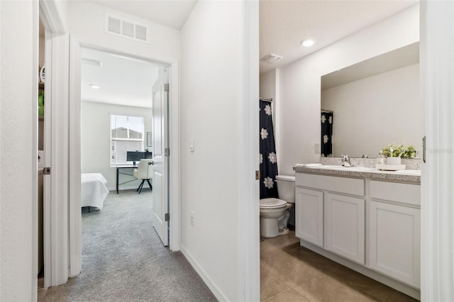 bathroom with tile patterned flooring, vanity, and toilet