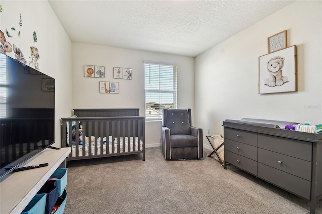 carpeted bedroom with a nursery area and a textured ceiling