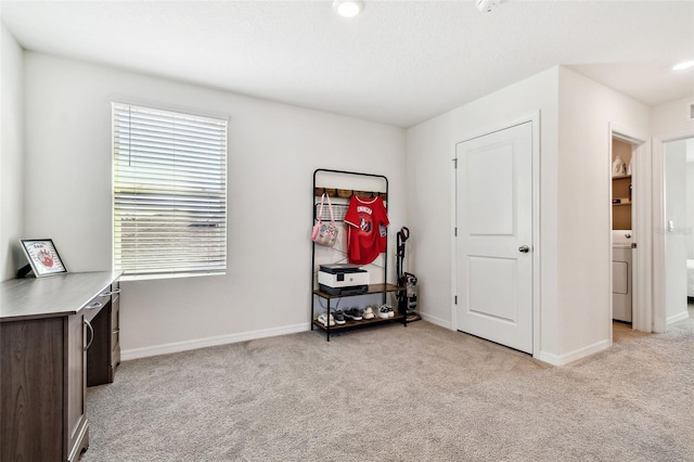 miscellaneous room with light carpet and washer / clothes dryer