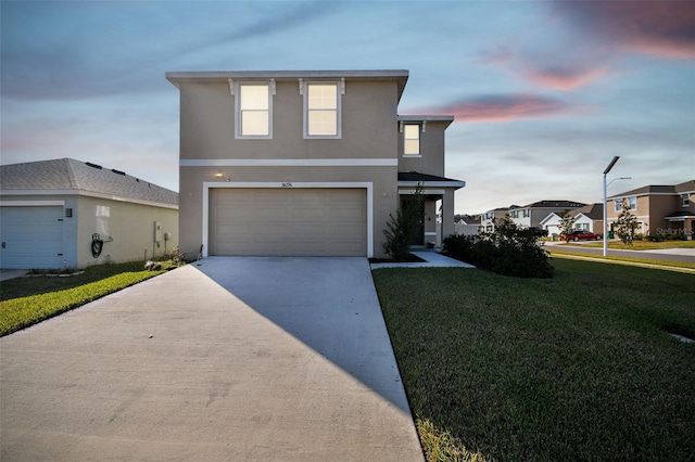 front facade featuring a garage and a lawn