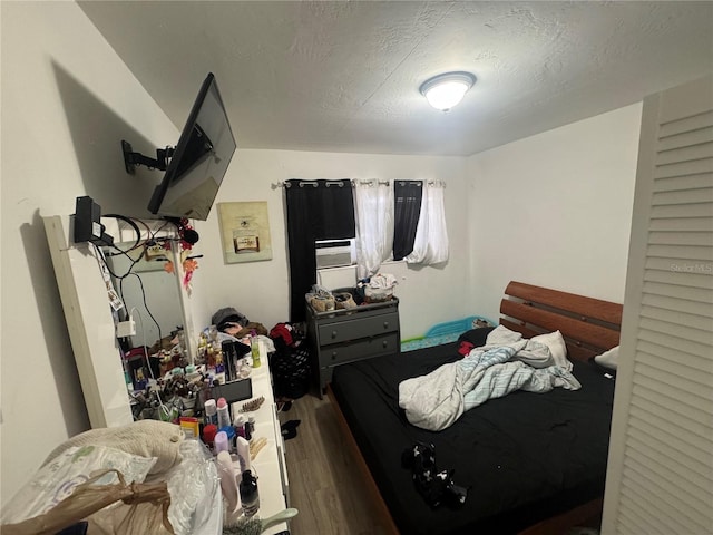 bedroom with wood-type flooring and a textured ceiling