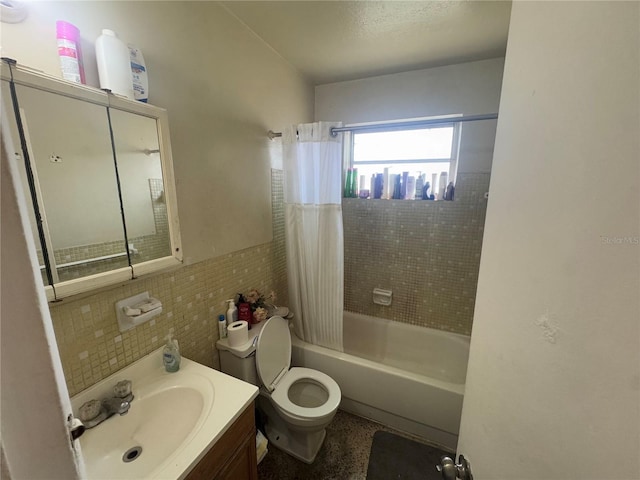 full bathroom with vanity, toilet, shower / bath combo with shower curtain, and tile walls