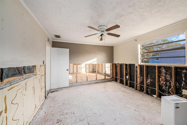 unfurnished room featuring ceiling fan, a textured ceiling, and ornamental molding