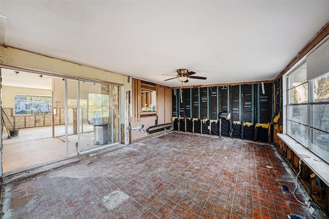 unfurnished sunroom featuring ceiling fan