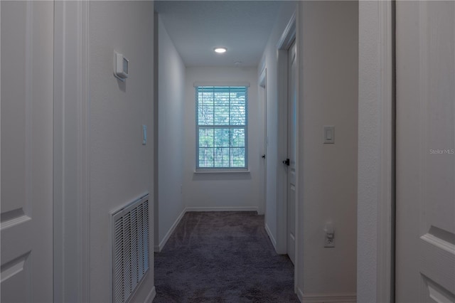 hallway featuring dark colored carpet