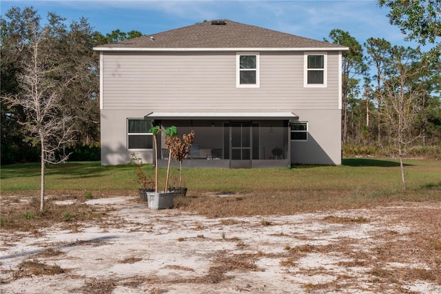 rear view of property featuring a sunroom and a yard